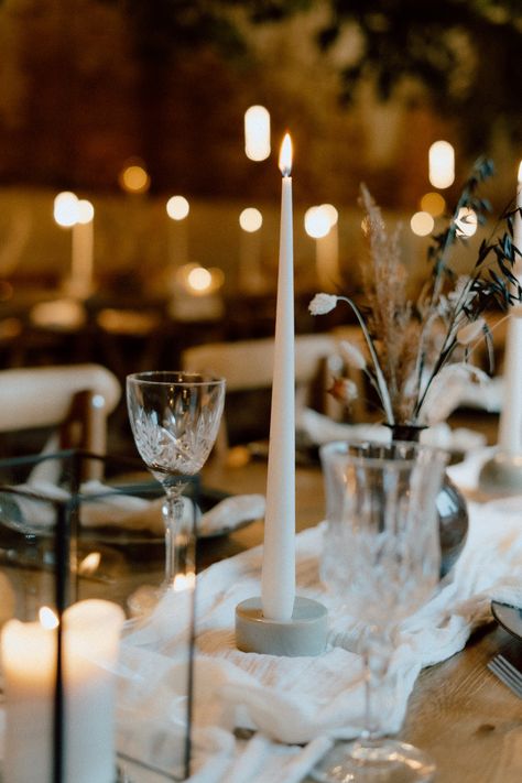 This image shows a barn wedding dining area. The overall vibes are rustic luxury. On the dining tables are white table runners, vases, candlesticks, tableware and glassware. The focus of the photo is on the table top, on a small blue ceramic candle holder with a white tapered candle. Blue Candle Holder, Candlestick Collection, Blue Candle Holders, Blue Candle, Ceramic Candle Holders, Ceramic Candle, Modern Vibe, Led Candles, Blue Ceramics