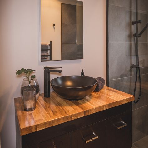 Nice bathroom vanity with black bowl on top of a varnished timber top beside a tiled shower with black fittings. A mirror is positioned above (Bathroom Renovations Christchurch). Bathroom Vanity Ideas Bowl Sink, Bathroom Vanity With Black Sink, Bathroom With Bowl Sink, Black Grey Wood Bathroom, Diy Black Bathroom Vanity, Black Vanity Wood Top, Bathroom Sink Bowls On Top, Black Bathroom Vanity With Wood Top, Small Vanity With Bowl Sink