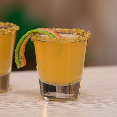 St. Patrick's Day cocktails don't get any crazier looking than these Pot O' Gold Shots. These little St. Patrick's Day Shooters mix up orange vodka and pineapple juice, and are garnished with gold luster dusty, gold sprinkles, and rainbow candy strips. We promise there are no better St. Paddy's Day shooters than these little bad boys! Candy Garnish Cocktails, Orange Shots Alcohol, Pot Of Gold Cocktail, Gold Shots, Orange Shots, Bar Management, St Patrick's Day Drinks, Orange Crush Cocktail, Holiday Bars