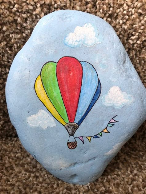 So graceful is this colorful hot air balloon floating across the cloud filled blue sky.  Measures 5 1/2“ x 4 1/2“ x 1“ Art Coquillage, Rock Painting Tutorial, Balloon Painting, Paint Rocks, Stone Art Painting, Painted Rocks Kids, Painted Rocks Craft, Painted Rocks Diy, Rock Painting Ideas Easy