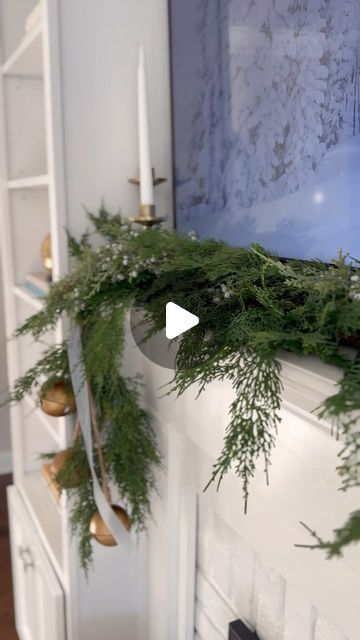 Taylor Collins Ash on Instagram: "Here's what I used to style our small space mantle for the holidays : - Two 6 ft. Faux Cedar Garlands from @studiomcgee - @command Cord Bundlers (one on the end + one in the middle of mantle) - 3 faux juniper & berry stems - large jingle bell strand - velvet ribbon (medium size) - bronze candlestick holders Everything linked over on my @shop.ltk -> https://liketk.it/4nyfY #ltkhome #ltkholidaystyle #ltkseasonal #holidaydecor #mantledecor #holidaygarland" Mantle Christmas Garland Ideas, No Garland Christmas Mantle, Garland On Console Table, Minimalist Christmas Mantle Decor, Cedar Garland Mantle, Bells Hanging From Mantle, Fireplace Garland And Bells, Mantle Garland With Bells, Christmas Mantel Garland Target