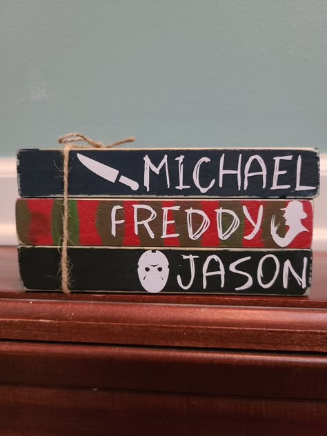 "This mini book stack is perfect for Halloween! It includes 3 books that say Michael, Freddy, and Jason. Perfect for any scary movie fan. The top book is painted a dark blue, the middle book is red with green stripes, and the bottom book is black. They all have white vinyl lettering. Thye have been distressed for a rustic look and are tied together with jute twine. They measure 6x4\"." Mini Book Stacks, Movies Scary, Horror Crafts, Books Halloween, Halloween Cricut, Faux Books, Halloween Wood Crafts, Dollar Store Halloween, Halloween Horror Movies