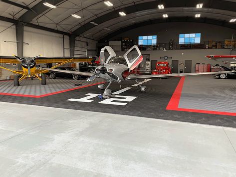 Ribtrax is the perfect complimentary flooring in this hangar. Taking this space to a new level. #Hangar #Aircraft #HangarFlooring #Swisstrax #Ribtrax #Cirrus Aircraft Hangar Home, Airplane Hangar Man Cave, Aircraft Hanger House, Hangar Homes Floor Plans, Airplane Hangar Design, Hangar Decor, Private Hangar, Hangar Architecture, Aircraft Hangar Design