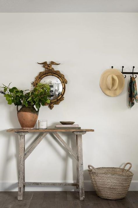 A gray reclaimed wood sawhorse console table sits on a wood floor and is styled with a clay jug vase. Wood Entry Table, Cottage Remodel, Clay Jug, Grandma Chic, Brown Lamps, Reclaimed Wood Console Table, White Shiplap Wall, Bamboo Mirror, Wooden Basket