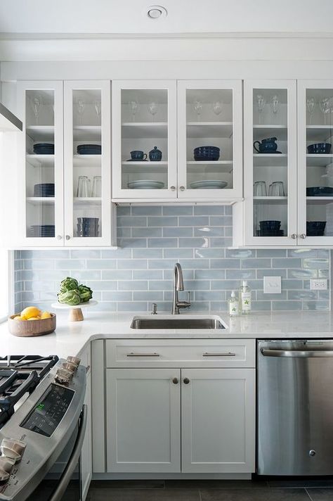 an airy white kitchen with a light blue subway tile backsplash and neutral metallics is very welcoming Blue Backsplash Kitchen, Серая Кухня, Subway Tile Backsplash Kitchen, Subway Tile Kitchen, Kitchen Backsplash Designs, All White Kitchen, Coastal Kitchen, Kitchen Tiles Backsplash, Kitchen Redo