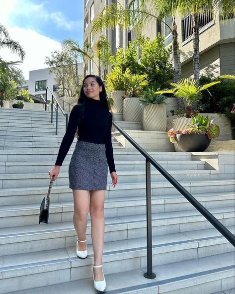 Girl standing on stairs while wearing a black turtleneck sweater, gray tweed skirt, and white Mary Jane heels Outfits With White Mary Janes, White Heels Outfit Casual, White Mary Jane Shoes Outfit, Mary Jane Shoes Outfit Skirts, White Tweed Skirt Outfit, Mary Jane Pumps Outfit, White Mary Janes Outfit, White Flats Outfit, Mary Jane Heels Outfit