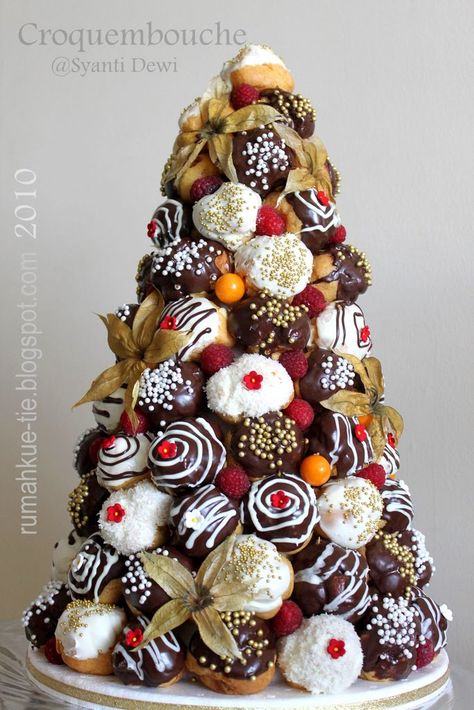 Stunning white and dark chocolate croquembouche with physalis fruits. Profiterole Tower, French Wedding Cakes, Wedding Cake Alternatives, Chocolate Wedding Cake, Christmas Menu, Xmas Food, Snacks Für Party, Christmas Cooking, Christmas Tea