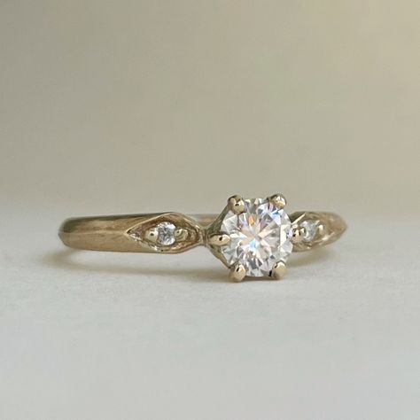 This engagement ring is handcrafted and made to order. band is 2mm x 1.25mm available in 10kt yellow gold and 14kt yellow gold using ethically sourced scs recycled gold. choose your gemstones. lab diamond  white sapphire  moissanite  Center stone 5mm round halve a carat. Side stones are 1.5mm If you want a different gemstone then what is offered please send me a message to discuss I am happy to help. Please allow 2-3 weeks for me to make your ring before shipment. I offer shipping within Canada Small Diamond Engagement Ring Vintage, Cheap Classic Engraved Engagement Ring, Simpler Vintage Engagement Ring, Vintage Solitaire Engagement Ring, Vintage Gold Engagement Rings, Ring Inspiration, Cottage Wedding, Sterling Silver Wedding Band, Silver Wedding Bands