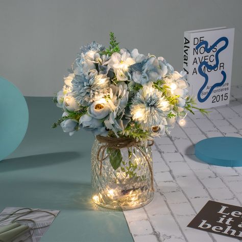 PRICES MAY VARY. PACKAGE - Including LED lights, 3 aritficial Blue Rose Bouquets and a Glass Vase. Total height is about 13”/33CM. Vase height is 6.3"/16CM. Flower height is about 13”/33CM. CREATIVE LED DECORATION - This Table LED flowers is perfect for your wedding, party, baby shower or home decor, etc. EASY TO SET UP- Put half of the led lights in the vase, and wrap the rest around the fake flowers. The LED lights have 8 remote control mode. LIGHT UP YOUR LIFE - The entire flowers and vase ar Artificial Flower Arrangements Centerpieces, Quince Centerpieces, Blue Wedding Centerpieces, Baby Blue Weddings, Blue Wedding Decorations, Blue Party Decorations, Centerpiece Home, Blue Centerpieces, Lighted Centerpieces