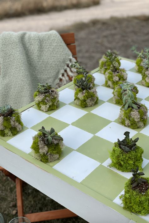 I made the cutest checkerboard table with moss covered succulents for game pieces! #airbnbdesign #cottagegames #checkerboardtable #outdoorgames #greenandwhitecheckerboard #DIYhomedecor Concrete Board, Checkerboard Table, Rustoleum Spray Paint, Green Succulents, Anthropologie Candle, Concrete Containers, The Color Green, Moss Art, Checkerboard Pattern