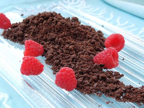 Chocolate cookie crumbles piled on a clear ice glass plate set on a turquoise blue linen.  Fresh red raspberries are scattered around sand on plate. Chocolate Streusel Topping, Chocolate Soil Recipe, Chocolate Crumble Topping, Cookie Crumble Recipe, Crumble Recipe Topping, Cookie Crumble Topping, Chocolate Crumble Recipe, Desserts Parfaits, Chocolate Cookie Crumble