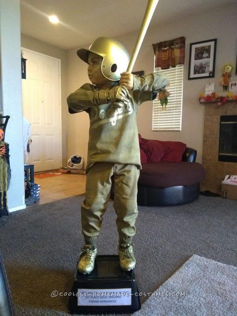 This trophy costume is one of the easiest costumes we have done. We already had everything since my son has played sport’s. We went with baseball trophy. We used an old uniform, spray painted it gold. For his hands and face we purchased some gold face paint Amazon for less than $10 bucks. The base ... Read more The post Shiny DIY Baseball Trophy Costume for a Boy appeared first on Coolest Homemade Costumes. Gold Trophy Costume, Baseball Trophy Costume, Baseball Card Costume, Diy Baseball Trophy, Trophy Costume, Referee Costume, Baseball Costumes, Diy Trophy, Sports Halloween