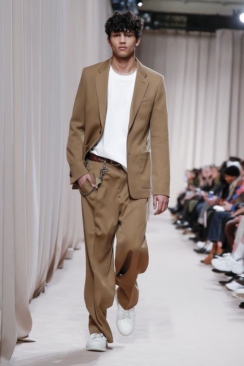 The Ami Fall Winter 2019 collection finds its inspiration in the plush, muted atmosphere of a Parisian apartment. Of crushed velvet and hounds-tooth revisited. A grandfather’s coat that is too large for the shoulders of a new generation. Yet its oversize silhouette dialogues well with the audacity of youth. The shoulder line low and waistline high, uplifted by fresh light tones for winter. Men Autumn Outfit, Gentleman Mode, Beige Suit, Suits And Sneakers, Autumn Outfit Ideas, Dresses For Men, Ami Alexandre Mattiussi, Alexandre Mattiussi, Fall Outfits Men