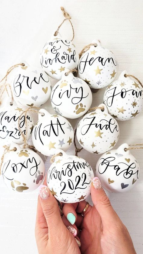 The perfect stocking filler or decoration for your tree. These white ceramic baubles are painted white, personalised with hand-lettered calligraphy and tied with brown twine ready to display proudly on your Christmas tree. The calligraphy baubles make the perfect keepsake and can be personalised with the wording of your choice.  These baubles are a perfect secret santa gift or for marking a milestone such as a first christmas, new home or engagement or getting married.  What can I have on my bau Personalised Ceramic Baubles, Ceramic Baubles Christmas, Hand Painted Baubles, Bauble Ideas, Personalised Baubles, First Christmas New Home, Folk Christmas, Christmas Table Decorations Centerpiece, Business Crafts