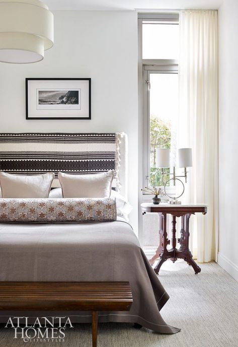 An African blanket affixed to the guest bedroom headboard gives the space graphic interest. The nightstand is an ornate antique table passed down from the homeowner’s grandparents. The chandelier is by Rejuvenation, while the wool-and-silk carpet is from Patterson Flynn Martin. Grandparents Bedroom Ideas, Grandparents Bedroom, Atlanta Homes And Lifestyles, Bath Makeover, Masculine Bedroom, Maximalist Interior, Bedroom Bedding, Silk Carpet, Atlanta Homes