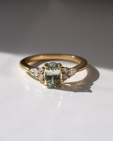 THE NANAMI🤍 Oval cut green sapphire Pear and round side diamonds 1.3ct centre stone 18k Recycled gold 6 - 8 weeks to craft from order Ships worldwide Handmade in London💕 #ovalcut #ovalcutengagementring #ovalcutdiamond #greensapphire #londonjeweller #engaged #engagementring Green Diamond Ring, Gold Engagement Ring Diamond, Green Engagement Rings, Vintage Wedding Rings, Green Diamond Rings, Nature Inspired Engagement Ring, Green Sapphire Ring, Cute Engagement Rings, Oval Cut Engagement Ring