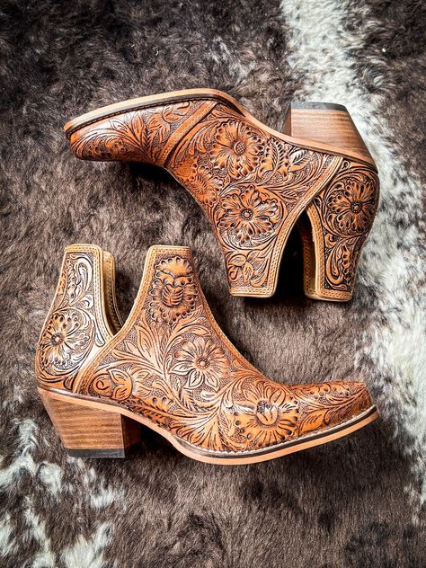 Step into the epitome of Southwestern flair with these Western leather booties, meticulously hand-tooled to highlight a stunning blend of rich bourbon hues. Featuring classic cowboy heels and convenient side slits, they blend traditional craftsmanship with modern ease. The intricate design, showcasing a pattern of desert blossoms, adds a distinctive touch of elegance. Ideal for transforming any ensemble, these tooled boots exude statement-making style with every step. 2" slanted heel. 6-11 not a Tooled Boots, Cowboy Heels, Hay Bag, Classic Cowboy, Pick Your Poison, Wrap Boots, Horse Boots, Western Leather, Mens Fragrance