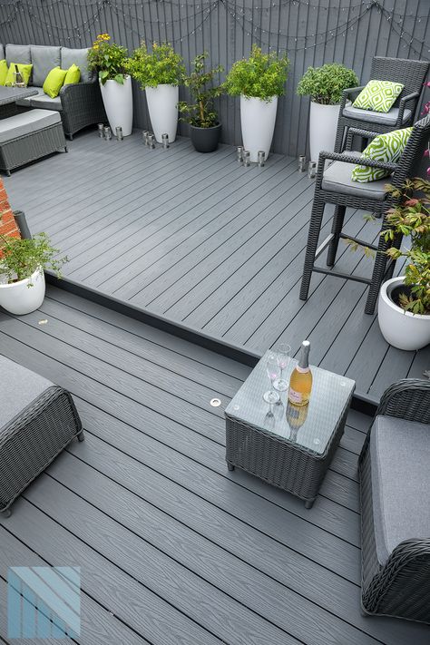 Modern garden design with anthracite grey decking Styling Decking Area, Grey Garden Decking, Decking And Fence Colour Ideas, Decked Seating Area, Decking Designs Layout, Decking Paint Ideas, Timber Decking Ideas Outdoor, Composite Decking Ideas Garden, Decking Area Ideas