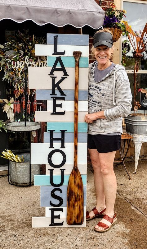 We use some scrap wood from other signs in various lengths and widths. Painted them a few different colors, took an old paddle burned it and then stained it and added some letters. Lake Themed Crafts, Lake Yard Ideas, Oars On Wall Decor Ideas, Lake House Decorating Ideas, River House Decor, Dock Ideas, Lake House Interior, Diy Beach Decor, Lake Gifts