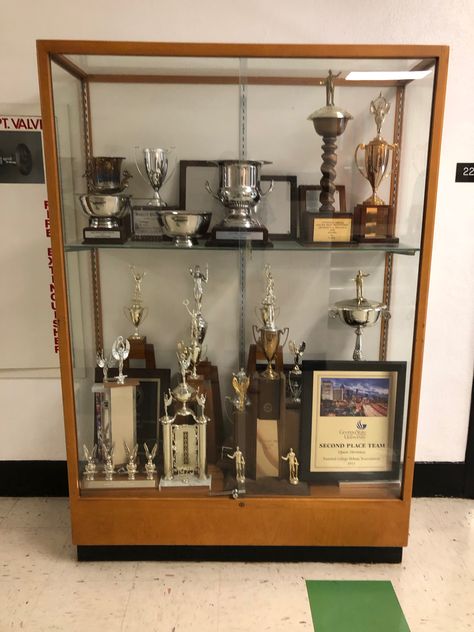 This trophy case is located on the second floor in the Funkhouser Building. This caught my eye because  I noticed all the trophies were for different thing but did not say specifically. I started wondering who were awarded these trophies? Where they for a Sport, Academics, or recognizing a certain department in the building or here on campus? How long do the awards date back to? Modern Trophy Display Ideas, Award Shelves, Trophy Display Shelves, Painted Trophies, Trophy Cabinets, Trophy Stand, Trophy Display Case, Trophy Wall, Wooden Award