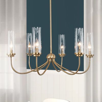 This chandelier is reminiscent of classic candlestick designs but has an updated look that's sure to please. Unveiled with a timelessly contemporary and modern essence, this brass chandelier features six arms softly branch upside for an elegant silhouette. The slim-seeded glass shades on one hand add more visual interest and in another hand produce a romantic atmosphere. Discover the understated luxury touch in the electroplate copper finish. This wagon wheel chandelier ensures plenty of fascina Elegant Dining Room Chandelier, French Style Chandeliers, Transitional Dining Chandelier, Small Dining Room Chandelier, Simple Dining Room Light Fixtures, Over Table Light Fixture, Dining Chandelier Ideas, Over Dining Table Lighting, Gold Chandelier Dining Room