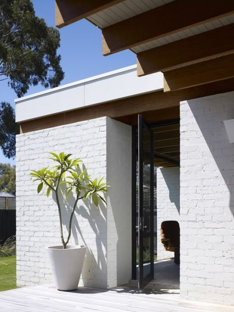 Exposed beams, painted white brick, and saw-cut travertine tiles make up a neutral palette. White Brick House, Architecture Extension, Facades Architecture, Modern Brick House, Brick House Designs, Hampton House, Brick Exterior House, Exterior Wall Design, Wall Exterior