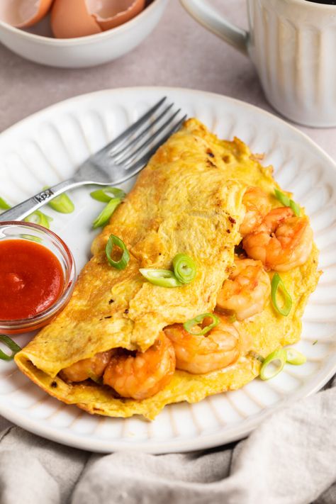 This simple shrimp omelette is a delicious, high-protein way to start the day. Featuring tender shrimp sautéed with green onions in savory soy sauce and rice wine vinegar, enclosed in a fluffy mixture of eggs and milk, this easy entrée is full of flavor and ready in no time at all. Omlet With Shrimp, Fish And Eggs, Shrimp Omelette Recipe, Breakfast Shrimp Ideas, Shrimp Omelet Recipes, Shrimp Breakfast Recipes, Shrimp Breakfast, Breakfast Shrimp, Shrimp Omelette