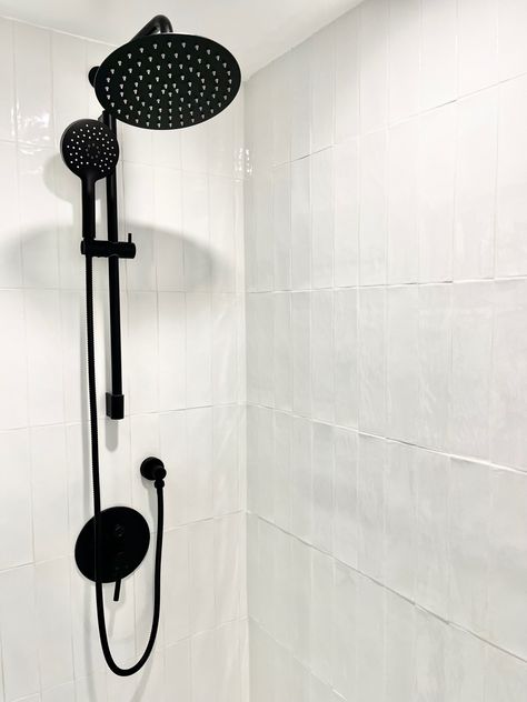 Black Showerhead Bathroom, Shower Tile Ideas Modern, Glossy Shower Tile, Vertical Shower Tile Ideas, Black And White Shower Ideas, White Shower Ideas, Vertical Bathroom Tile, Showerhead Ideas, White Bathroom Ideas Modern