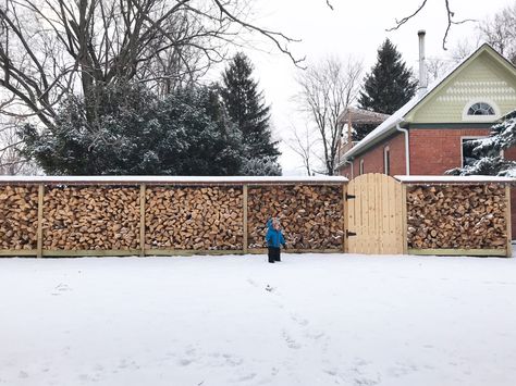 Functional, beautiful wood fence. Made from split firewood. Unique, eye-catching design idea. Privacy fence. DIY on a budget. Doubles as firewood holder. Firewood Fence Ideas, Pallet Firewood Storage Backyard, Firewood Fence, Outdoor Firewood Storage Ideas, Firewood Wall, Build Corigated Tin Firewood Holder, Privacy Fence Diy, Log Wood Shed Firewood Storage, Pallet Wood Rack Firewood Storage