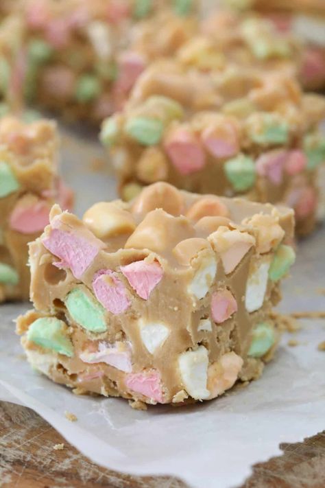 A peanut butter slice full of coloured mini marshmallows and cut into squares. Marshmallow And Peanut Butter Squares, Colored Marshmallow Squares, Rainbow Marshmallow Squares, Peanut Butter Squares Marshmallow, Pb Marshmallow Squares, Coloured Marshmallow Recipes, Marshmallow Peanut Butter Rice Krispies, Marshmallow Dream Bars, Peanutbutter Marshmallows Squares