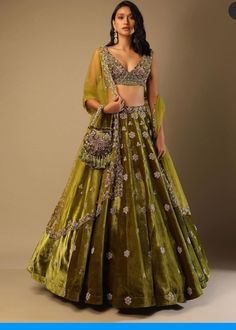 Lehenga Choli for Wedding Wear is stunningly embroidered in dabka, tilla, and sequins work on white raw silk choli paired with Raw Silk Green Lehenga and Net Pink Dupatta. ﻿A blossoming pink hue dupatta is paired up with a handcrafted mastery of pearls, zardosi, and sequins laid over an emerald green lehenga and a white choli in pure raw silk. Choli: Beautiful dress is gonna make your big day more beautiful in its design and styling having embroidered choli in without sleeves inc Green Lehenga Choli, Long Gown For Wedding, Velvet Lehenga, Wedding Lehenga Designs, Kalki Fashion, Lehnga Dress, Green Lehenga, Choli Designs, Embroidered Velvet