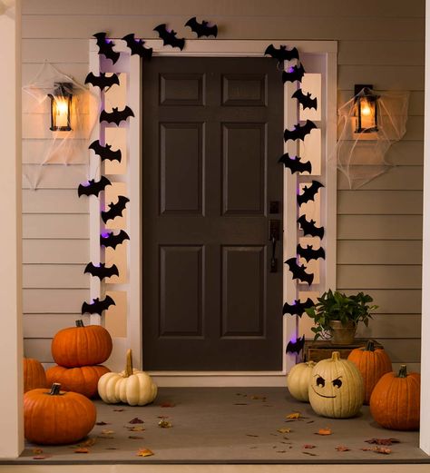 A bat colony at your front door? Hang our Light-Up Bat Colony String Lights and greet friends and neighbors with a batty smile! Cluster the two 10’L strands together to resemble a bat colony, or arrange in any way you like. (Sure, we know bats don’t really exude a purple glow…but that just adds to the spooky fun factor!) These lights can be used inside or in a covered area outdoors. A simple way to add some fun décor to your Halloween decorations! 2 AA batteri Porta Halloween, Porche Halloween, Halloween Decorations Outdoor Porch, Halloween Decor Diy, Porch Lights, Halloween Front Doors, Casa Halloween, Halloween Front Porch Decor, Easy Halloween Decorations