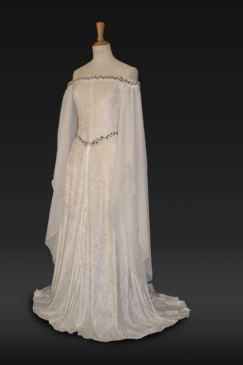 "Medieval Dress, Elvish Wedding Dress, Handfasting Dress, Elvish Gown,  Renaissance Gown, Medieval Gown, \"Guinevere\"  frockfollies is proud to add this beautiful new design to the collection. Guinevere is pure elegance in ivory crushed velvet with an elaborately embroidered off  the shoulder neckline and belt in an ivy design. It has a really romantic, elegant feel. The embroidery is in dark and light olive green. The long hanging sleeves are in ivory chiffon. The train can be made shorter at no extra cost. It is designed and custom made by Gill Linley of frockfollies. Perfect for so many occasions: Medieval, Renaissance, Elvish Weddings, Hand Fasting ceremonies, LARP events, Re Enactments, Masquerade Balls or your 'inner goddess' moments! Hand made in England by an experienced theatrica Medieval Dress White, White Medieval Dress, Elvish Wedding Dress, Elvish Dress, Midevil Dress, Handfasting Dress, Celtic Wedding Dress, Elvish Wedding, Medieval Wedding Dress