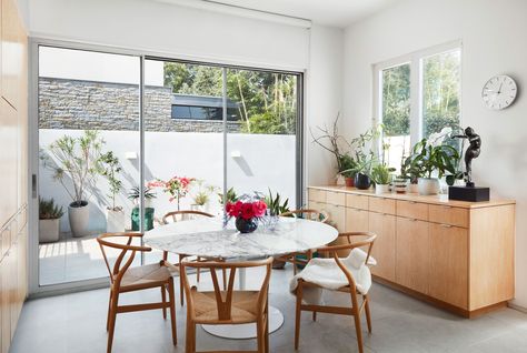 The couple kept to midcentury classics for the kitchens fussfree diningnbsp area a Saarinen Tulip table surrounded by... Marble Tulip Table, Ligne Roset Sofa, Wegner Wishbone Chair, Saarinen Tulip Table, Dallas House, Joe Cole, Tulip Dining Table, Tulip Table, Reproduction Furniture