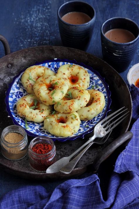 Khichu is a Gujarati, healthy and delicious, snack/breakfast that is gluten free and vegan. It is prepared with rice flour that is added to hot boiling water along with spices like ajwain and jeera. This mixture is then shaped into small disks with an indent in the centre and steamed in a idli cooker.  It is almost like having a savoury donut but unlike a regular donut, this one is dense and steamed. The process of making it is actually very interesting.  Serve... Veg Brunch Ideas, Jain Recipes For Dinner, Starters Indian, Veg Dinner Recipes Indian, Dinner Recipes Vegetarian Indian, Khichu Recipe, Samosa Pastry, Savory Donuts, Breakfast Cups Recipe