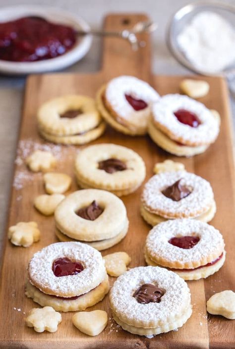 Italian sandwich cookies on a board with jam and powder sugar Cookies With Jam, Italian Butter Cookies, Peach Cookies, Italian Christmas Cookies, Italian Cookie Recipes, Italian Sandwich, Jam Cookies, Nutella Cookies, Chocolate Nutella