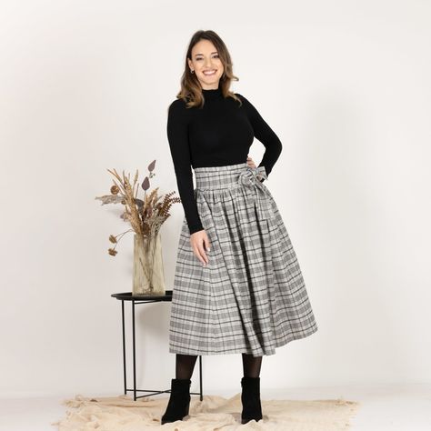 Elevate your wardrobe with our high-waisted midi wool skirt in plaid color. The soft wool fabric ensures warmth and comfort, while the timeless pattern adds sophistication to any outfit. A bow detail at the waist offers a whimsical yet polished touch, perfect for a day-to-night look.  Enjoy the effortless fit and the feminine sense when wearing our creations! Every piece by NikkaPlace is made with lots of love and attention to detail! Cool Wool Blend 70% Wool and 30% Polyester Machine Wash (40°) Do not tumble dry or bleach Wool Skirt, Women Midi, Wool Skirts, Night Looks, Soft Wool, Wool Fabric, Bow Detail, Wool Blend, Bleach