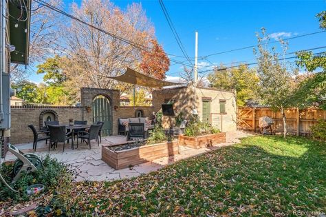 Credit: <a href="https://www.compass.com/listing/2590-birch-street-denver-co-80207/1187652556317558265/">Compass</a> Colorado Apartment, Bungalow Backyard, Round Doorway, Yellow Accent Walls, Raised Planter Boxes, Enclosed Patio, Globe String Lights, Wood Front Doors, Front Steps