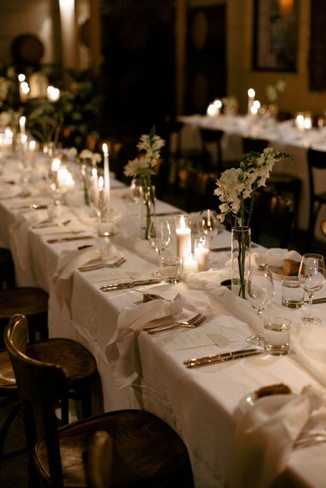 White Tablecloth White Napkin Wedding, Minimal Wedding Dessert Table, Cozy Rehearsal Dinner, Long White Table Wedding, Tablescape No Plates, Simple Candle Table Decor, White And Beige Table Decor, Candle Wedding Tablescape, Timeless Wedding Reception Decor