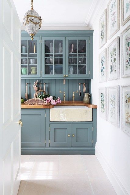 'Anyone can pick a paint colour, but getting the structure right is what makes a house', says Amanda Hornby, the interior designer who tranformed this Cotswolds dovecote into a family home. Amanda designed the cupboards in the kitchen, painted in Farrow & Ball's 'Card Room Green'. The green tone of the cupboards adds a fresh feel to the room, complimented by the green tones in the artwork on the gallery wall. Brass taps and fixtures give a feel of elegance to the simple style of the space. Railings Kitchen, Kitchen Paint Schemes, Kitchen Cabinet Inspiration, Casa Disney, Sophisticated Bathroom, Blue Kitchen Cabinets, Cabinets Ideas, Green Kitchen Cabinets, Farrow And Ball