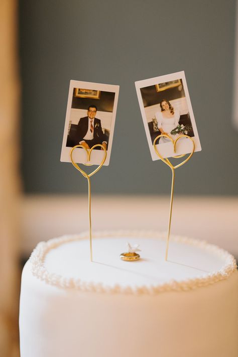 we took polaroids of each other before our wedding meal and used them as our cake topper along with a gold ring with a dove that my grandparents used on their wedding cake 63 years prior. Cake Topper Polaroid, Wedding Cake Toppers Polaroid, Minimalist Cake Topper Wedding, Polaroid On Wedding Cake, Alternative Wedding Cake Toppers, Diy Wedding Topper, Wedding Cake With Polaroid, Cake With Photo Topper, Simple Cake Toppers Wedding