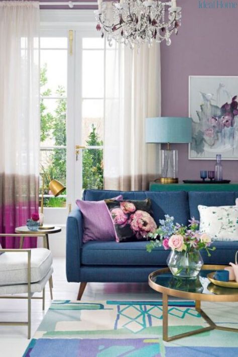 Give your living room a feminine update with a punchy purple decorating scheme. We’re not talking about decorating your living room with fierce, power-glam purples we all loved a few years ago, but a softer and easier plum that walks the line between feminine and masculine for an elegant feel you can take in any direction, from shabby chic to smart and contemporary. Just team your purple living room with the right neutral and be fearless with accents. #decoratingtips #purpleroomideas #livingroom Purple Living Room Furniture, Purple Living Room Ideas, Purple Living Room, Furnitur Ruang Keluarga, Boho Interior Design, Blue And, Living Room Color Schemes, Colourful Living Room, Room Color Schemes