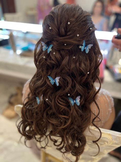 A bridal half open hairstyle with curly hair and hair is decorated with butterfly hair accessories and pearl hair accessories. Hair is highlighted to a soft brown and is tonged with a small tong Wedding Hairstyles With Butterflies, Cute Hairstyles For Long Hair For Wedding, Prom Hairstyles Butterflies, Cute Dress Hairstyles, Butterflies In Hair Hairstyles, Hairstyle Design For Wedding, Hair Styles For Prom Long, Butterflies Hairstyles, Trendy Wedding Hairstyles Indian