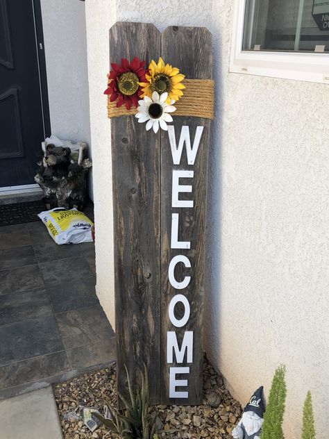 Rustic Welcome sign made from recycled fence boards, twine and painted wooden letters. The flowers clip on and can be changed out to fit the season. What To Do With Old Fence Boards, Rustic Welcome Sign Wedding, Fence Post Crafts, Fence Board Crafts, Picket Fence Crafts, Old Fence Boards, Rustic Welcome Sign, Fence Signs, Porch Wall Decor