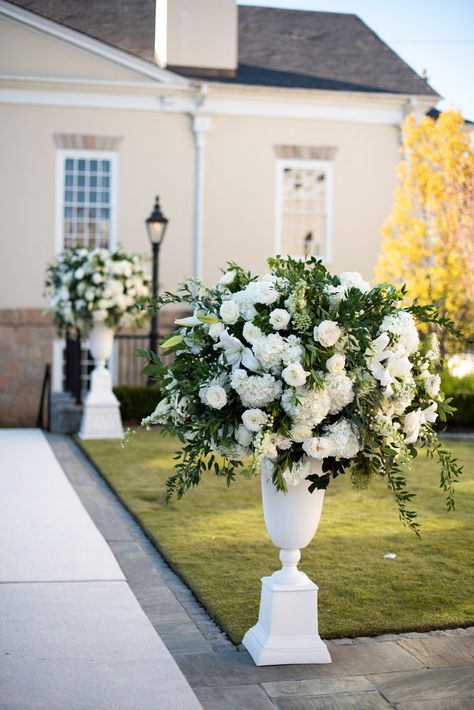 Lush white floral arrangements placed down wedding aisle designed by Edge Design Group | Piedmont Driving Club End Of Aisle Arrangements, White Wedding Aisle Decor, Large Vases Wedding Aisle, White Pedestal Wedding Ceremony, Ceremony Pillars, White Flower Urns Wedding, White Flowers Lining Wedding Aisle, Altar Florals, White Wedding Aisle