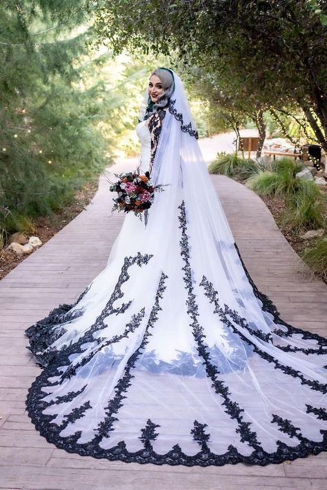 Our Raisa custom black and white mermaid wedding dress has been created for our bride, Raisa . It features gorgeous black lace with ivory satin/tulle , and it has a gorgeous illusion back with black buttons . The perfect choice for a halloween wedding!  If you need another custom gown to be made for you, kindly contact Brides & Tailor first. You can see videos of this gown on our instagram page: https://www.instagram.com/p/CeyIc6WP8jX/ Creepy Wedding Dress, Gothic Wedding Dress Black And White, Black And White Wedding Dress With Sleeves, White Wedding Dress With Black Lace, Wedding Dress With Black Accents, White Gothic Wedding Dress, Vampire Wedding Dress, Emo Wedding Dresses, White And Black Wedding Dress