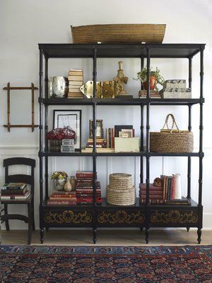 A bookcase, styled by Burnham Design, features a mix of handmade and mass-produced items. “Any accessory collection should include organic or handcrafted items. They offer a uniqueness and beauty that you can’t get from mass-market knickknacks,” says designer Betsy Burnham. #handmade #homedecor #design #Eurolight Etagere Bookcase Styling, Etagere Styling, Bookcase Styling, Boutique Interior Design, Bookshelf Styling, Coastal Living Rooms, Foyer Design, Etagere Bookcase, Pacific Palisades