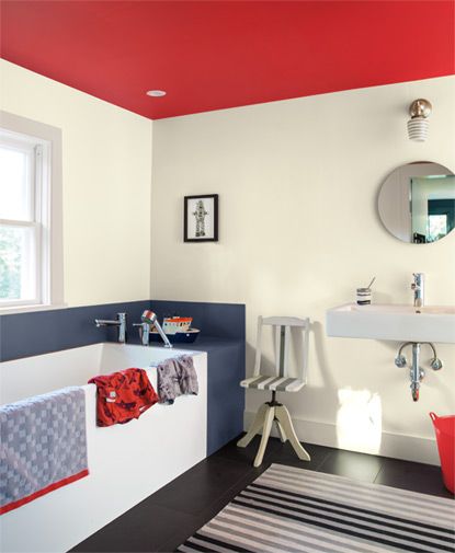 A bathroom features a round mirror over a contemporary sink; black and white colored walls and floors are accented by a red ceiling. Gloss Ceiling, Bathroom Color Ideas, Contemporary Sink, Tranquil Bathroom, Red Ceiling, Ceiling Paint, Arch Digest, Bathroom Paint, Kitchen Colour Schemes