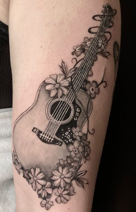 An absolutely breath-taking tattoo. @jenskinart does a phenomenal job with black and grey realism, and this guitar piece with florals is just beyond impressive, and it looks just like a photo! Music With Flowers Tattoo, Flower Music Tattoo, Guitar And Flowers Tattoo, Floral Guitar Tattoo, Acoustic Guitar Tattoo Design, Flower Guitar Tattoo, Guitar And Sunflower Tattoo, Feminine Guitar Tattoo, Acoustic Guitar With Flowers Tattoo