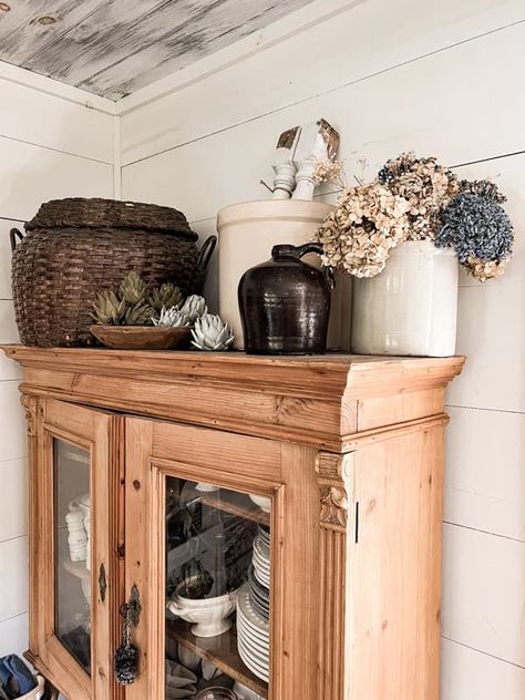 Dried flowers in vintage crock and thrift store basket on top of pine hutch for country chic farmhouse decor. Buffet Cabinet Decor Living Room, Baskets On Cabinets, Above Hutch Decor, Baskets On Top Of Hutch, Top Of Wardrobe Decor, Top Of Cupboard Decor Kitchen, Vintage Hutch Decor, Decorating Top Of Hutch Farmhouse, Decorate Top Of China Cabinet